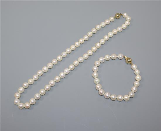 A single row uniform cultured pearl necklace with 18ct gold ball clasp and a similar bracelet with diamond-set ball clasp (85)